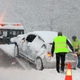 A tow truck picks up a stranded car in the snow